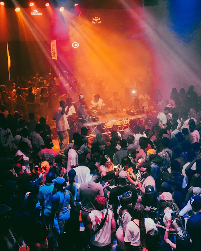 Energetic nightclub atmosphere with a lively crowd enjoying music under colorful lights.